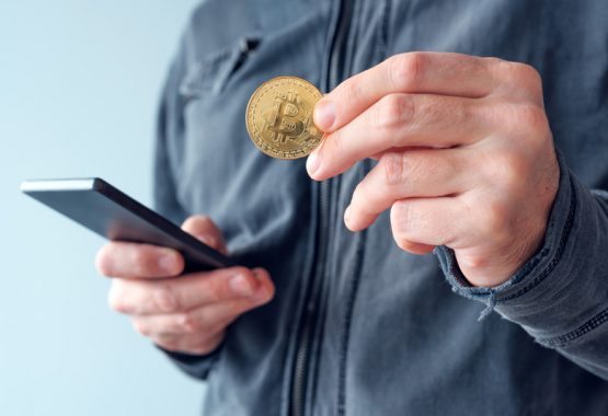 man-with-bitcoin-and-mobile-phone-P8NS7Y4 man-with-bitcoin-and-mobile-phone-P8NS7Y4