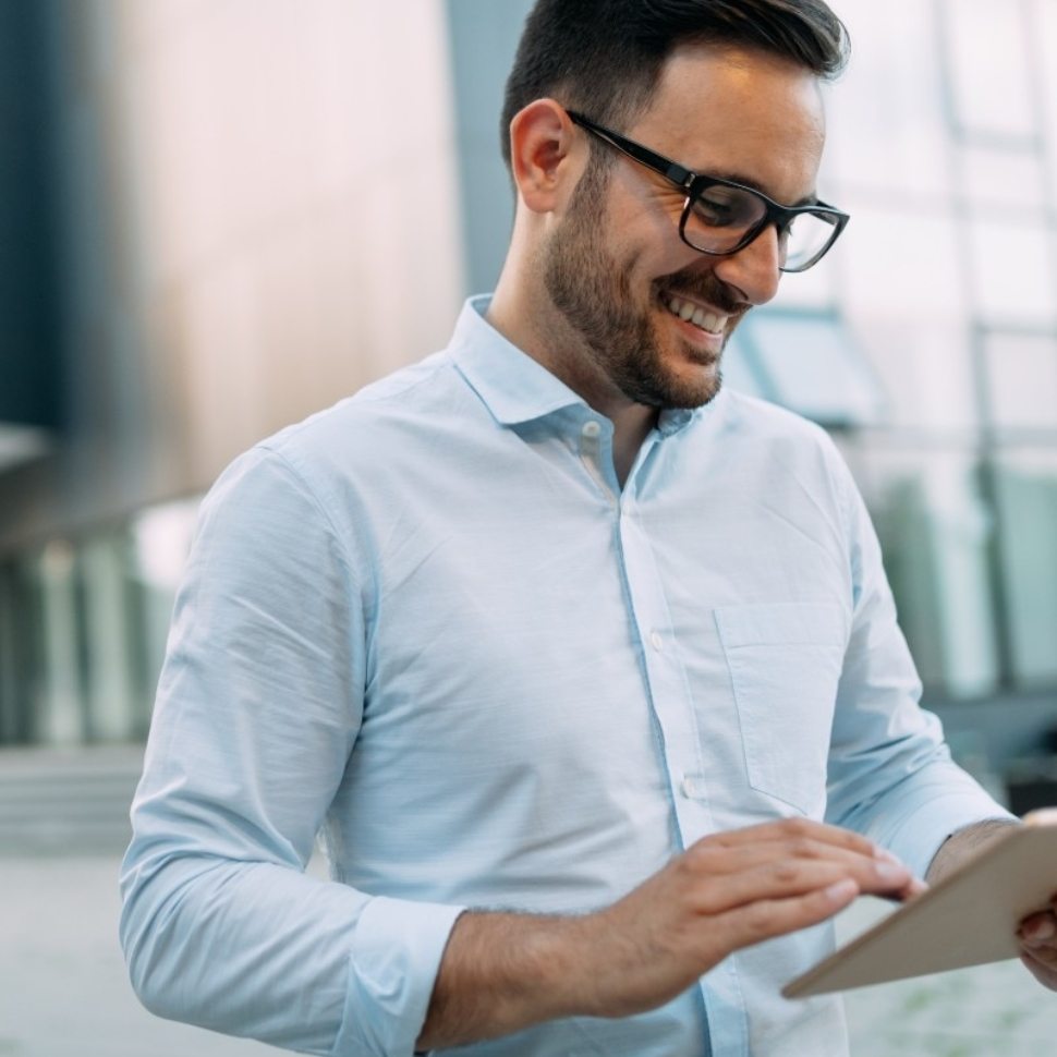 portrait-of-businessman-in-glasses-holding-tablet-AWVHCJU