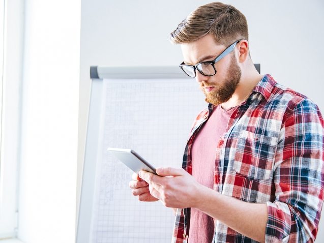 handsome-serious-man-with-beard-standing-and-PBYSCKB