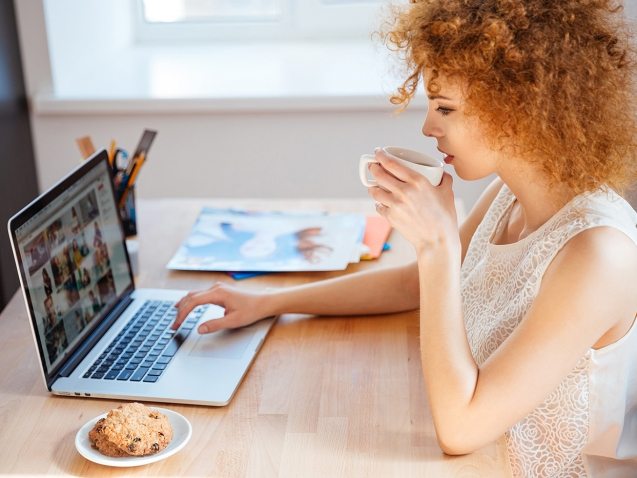 woman-photographer-drinking-coffee-and-working-PJNBP6U