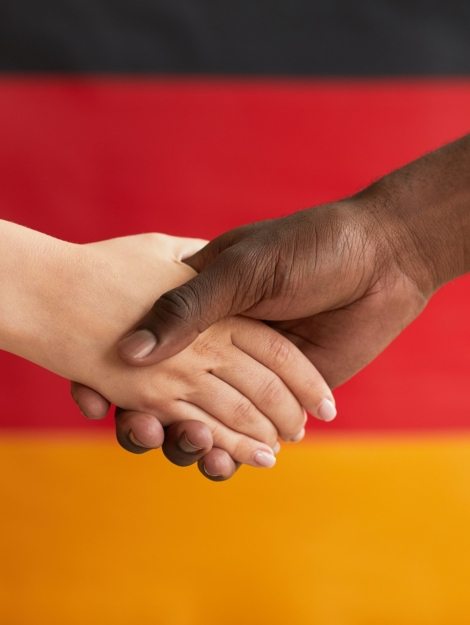 Close-up of people shaking hands against the German flag