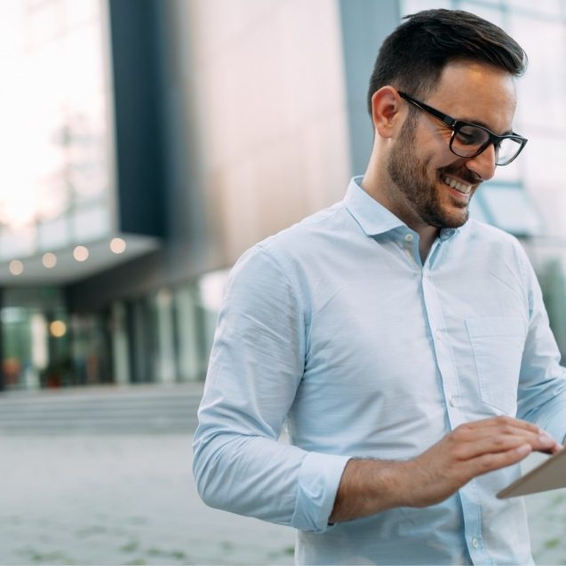 portrait-of-businessman-in-glasses-holding-tablet-AWVHCJU