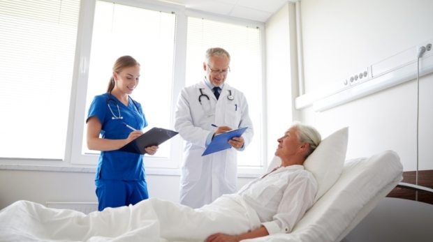 doctor-and-nurse-visiting-senior-woman-at-PA27SYD