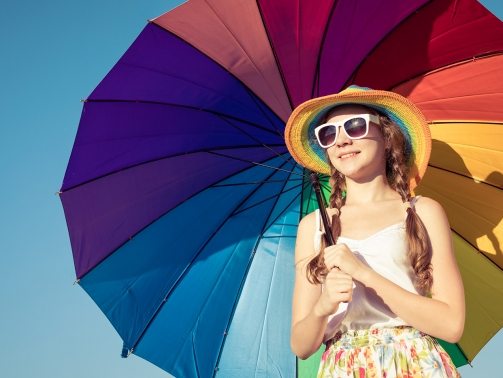 teen-girl-with-umbrella-standing-on-the-beach-at-PMEQ6S8