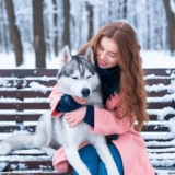 woman-sitting-on-the-bench-with-siberian-husky-PS9ZX58