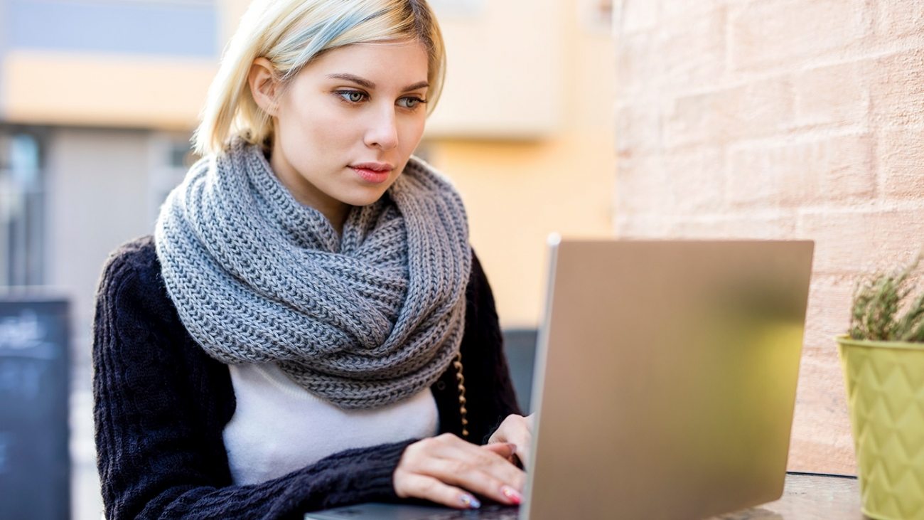 young-focused-woman-working-on-laptop-at-outdoor-PTTFVNE