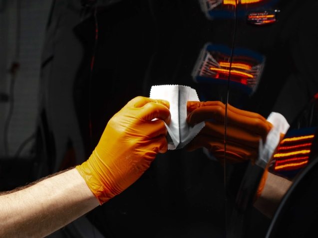 Car polish wax worker hands polishing car. Buffing and polishing vehicle with ceramic. Car detailing. Man holds a polisher in the hand and polishes the car with nano ceramic. Tools for polishing