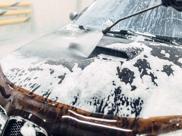 Carwash service, car cleaning, top view on hood. Auto detailing, washing foam off