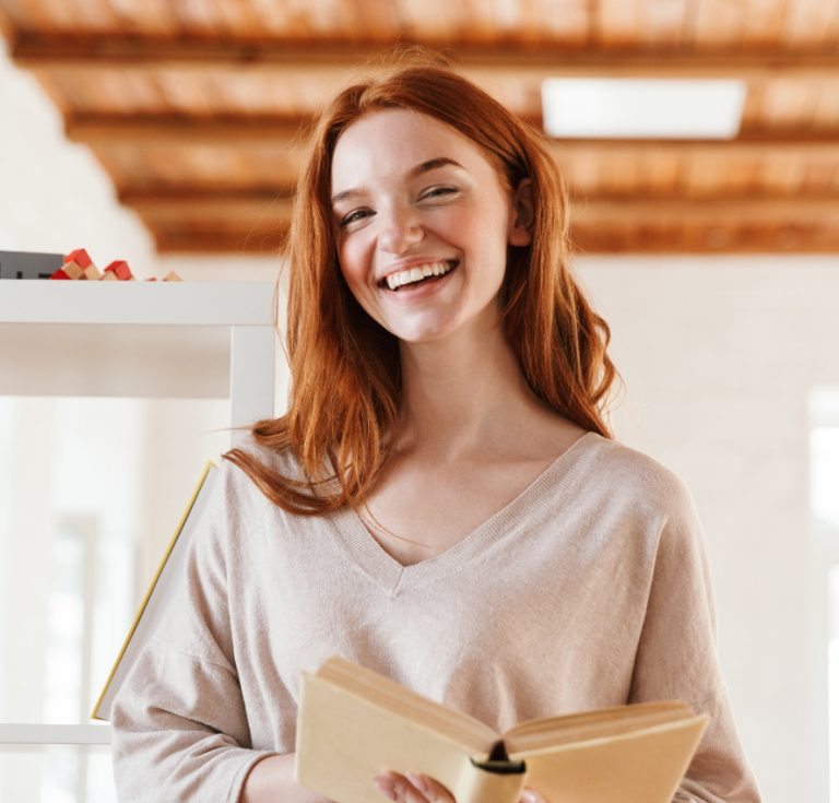 happy-redhead-young-lady-student-reading-book-M5Z7RVC@2x