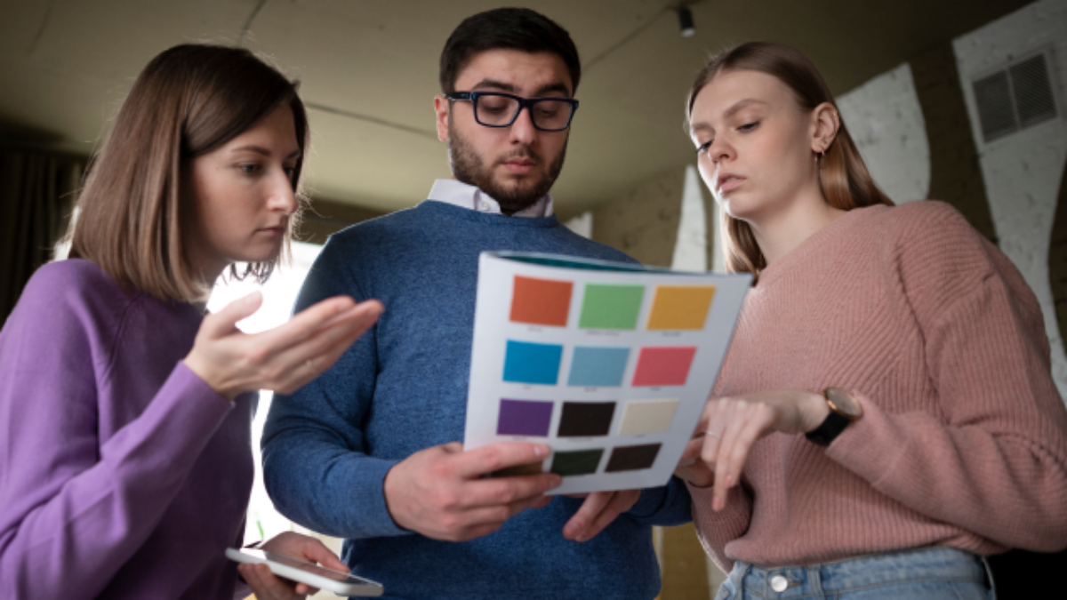 medium-shot-people-holding-notebook-low-angle 1