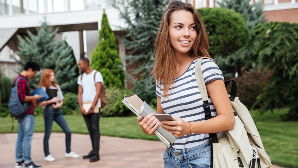happy-woman-student-with-backpack-holding-books-PNFUGG7(1)