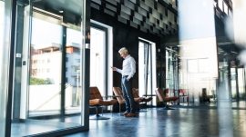 Mature-businessman-with-smartphone-in-the-office.