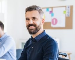 young-businessman-in-wheelchair-with-colleagues-EWTN4AC