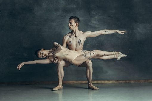 the-young-modern-ballet-dancers-posing-on-gray-JYBC7XQ