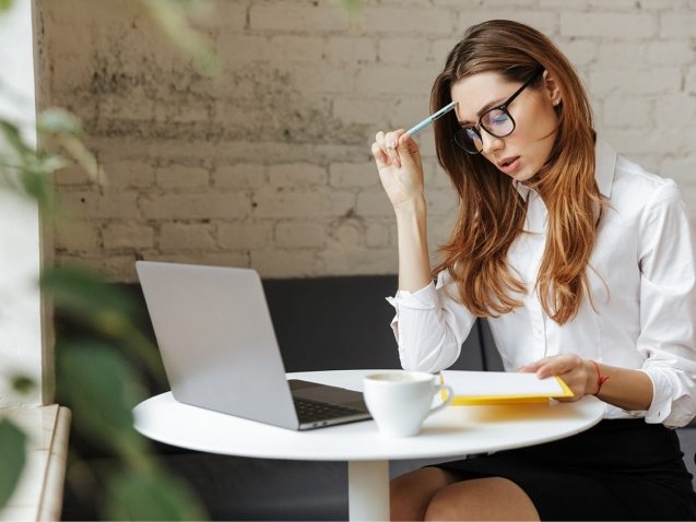 thoughtful-business-woman-indoors-using-laptop-P5HYUQX