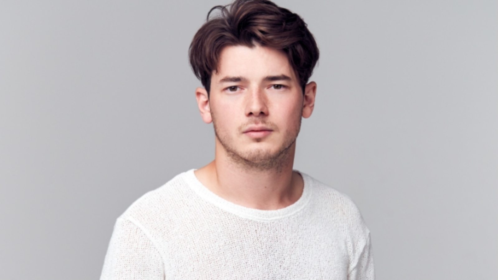 studio-portrait-of-young-man-with-serious-8YSPPQM