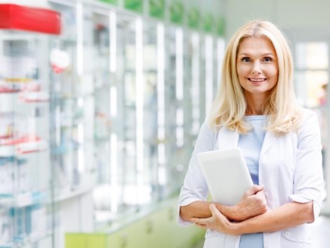 cheerful-pharmacist-holding-digital-tablet-and-smi-98L5GF6