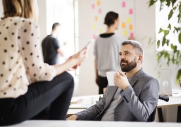 business-people-with-wheelchair-in-the-office-P9M4RX3