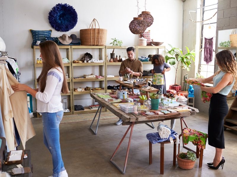 customers-and-staff-in-a-busy-clothes-shop-PKWD8LW