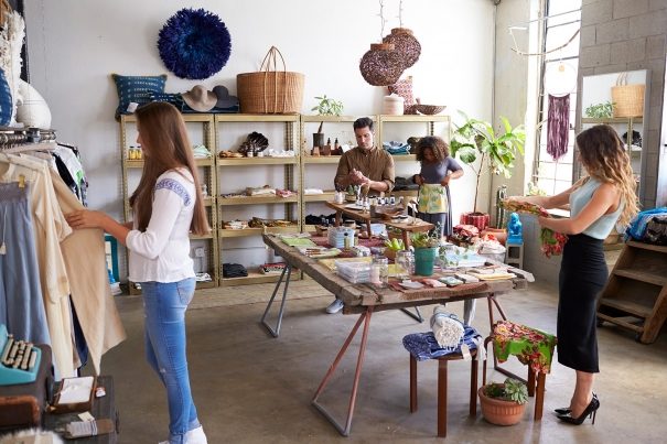 customers-and-staff-in-a-busy-clothes-shop-PKWD8LW