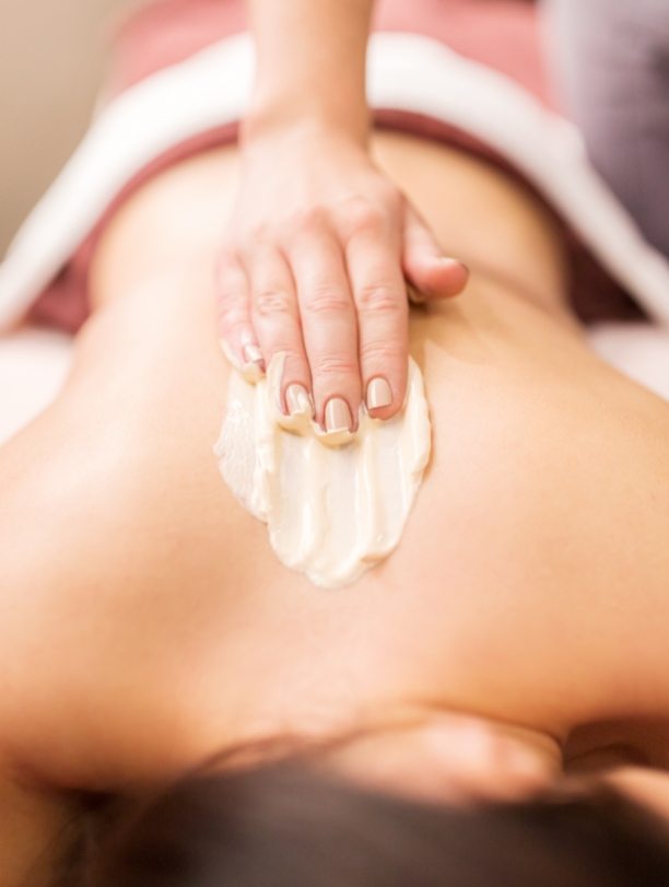 woman-having-back-massage-with-cream-at-spa-PFCWZ34