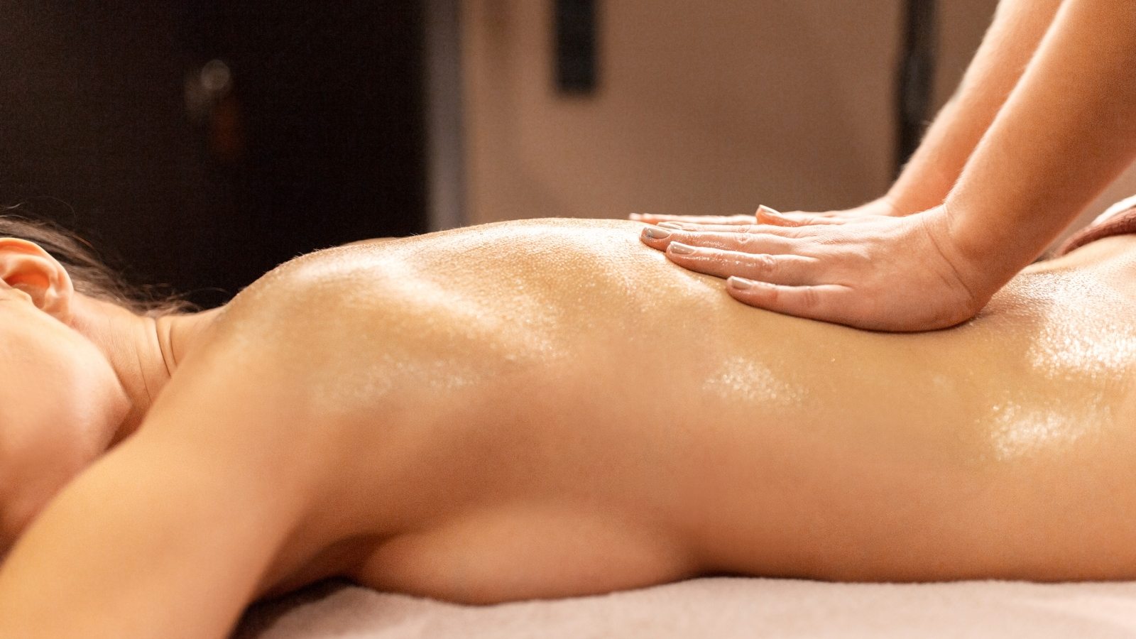 people, beauty, healthy lifestyle and relaxation concept - beautiful young woman lying and having back massage at spa