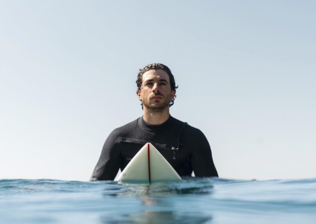 medium-shot-man-sitting-surfboard