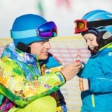 father-and-little-son-in-skiing-outfits-playing-PMSY642