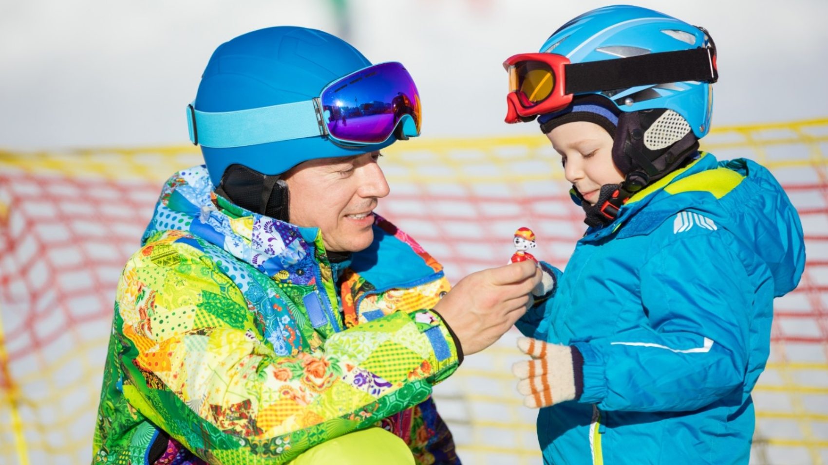 father-and-little-son-in-skiing-outfits-playing-PMSY642